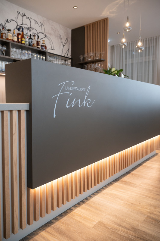 Elegante Bar aus dunklem Holz im Landrestaurant Fink